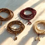Flere håndlavede mala kæder fra Nepal med træperler og naturperler liggende på et lyst træbord
